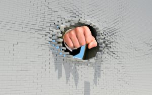 Fist punching through brick wall. Business concept