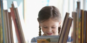 Caucasian girl taking book from shelf